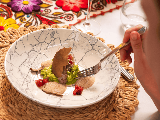 Postre gourmet con mousse de chocolate, salsa verde, fresas y decoración artística en Sumaq Machu Picchu Hotel