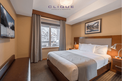 Comfortable bedroom at Falcon Crest Lodge features a king-size bed, a window with a mountain view