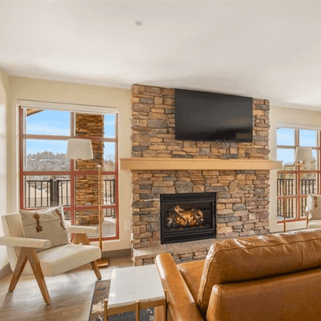 Spacious Appalachian Grand Suite Family Room featuring a walk-out patio, cozy couch, mounted TV, and fireplace