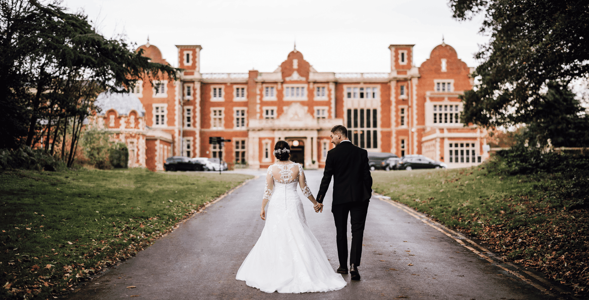 Bride and groom walking up to Easthampstead Park mansion house