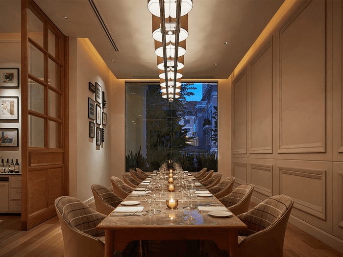 Opera dining room with a long wooden table, elegant chairs, and framed art at Park Hyatt Saigon