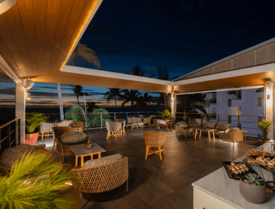 Outdoor dining tables with comfy chairs over looking sea in Sky Bar at Buenaventura Grand Hotel and Spa