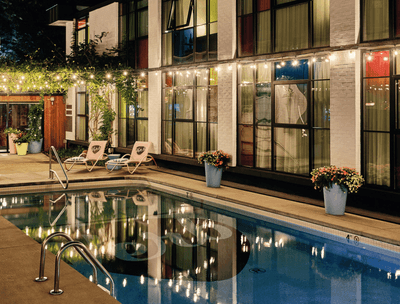 Outdoor pool area with sun loungers in The Verb Hotel at night