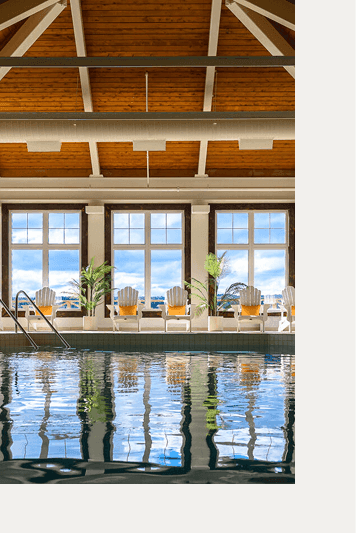 Luxury indoor pool with lounge chairs by big windows at Rodd Miramichi River, the best hotels in Charlottetown, PEI