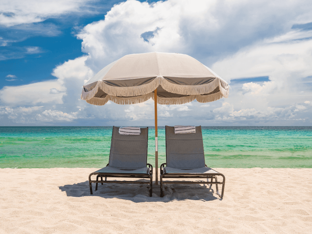 Sun beds with an umbrella in the beach at Plymouth Hotel