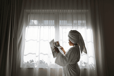 Lady in a bathrobe reading a magazine at South Beach Hotel