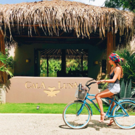 A lady riding a bicycle at Cala Luna Boutique Hotel