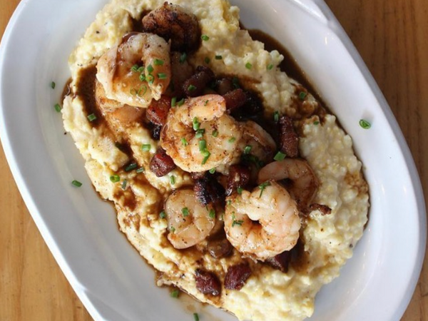 An blue collar restaurant grits and prawns  dish with gravy