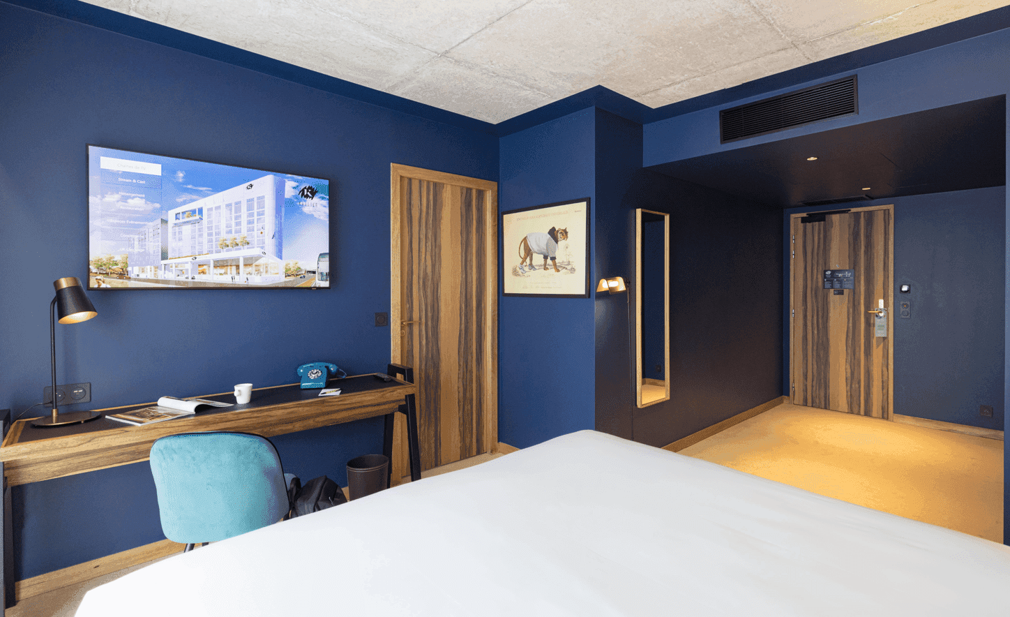 Bed & work area in Ekip Room at Kopster Hotel Paris Ouest Colombes