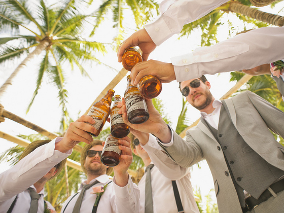 Group of men toasting beer bottles at Clevelander South Beach