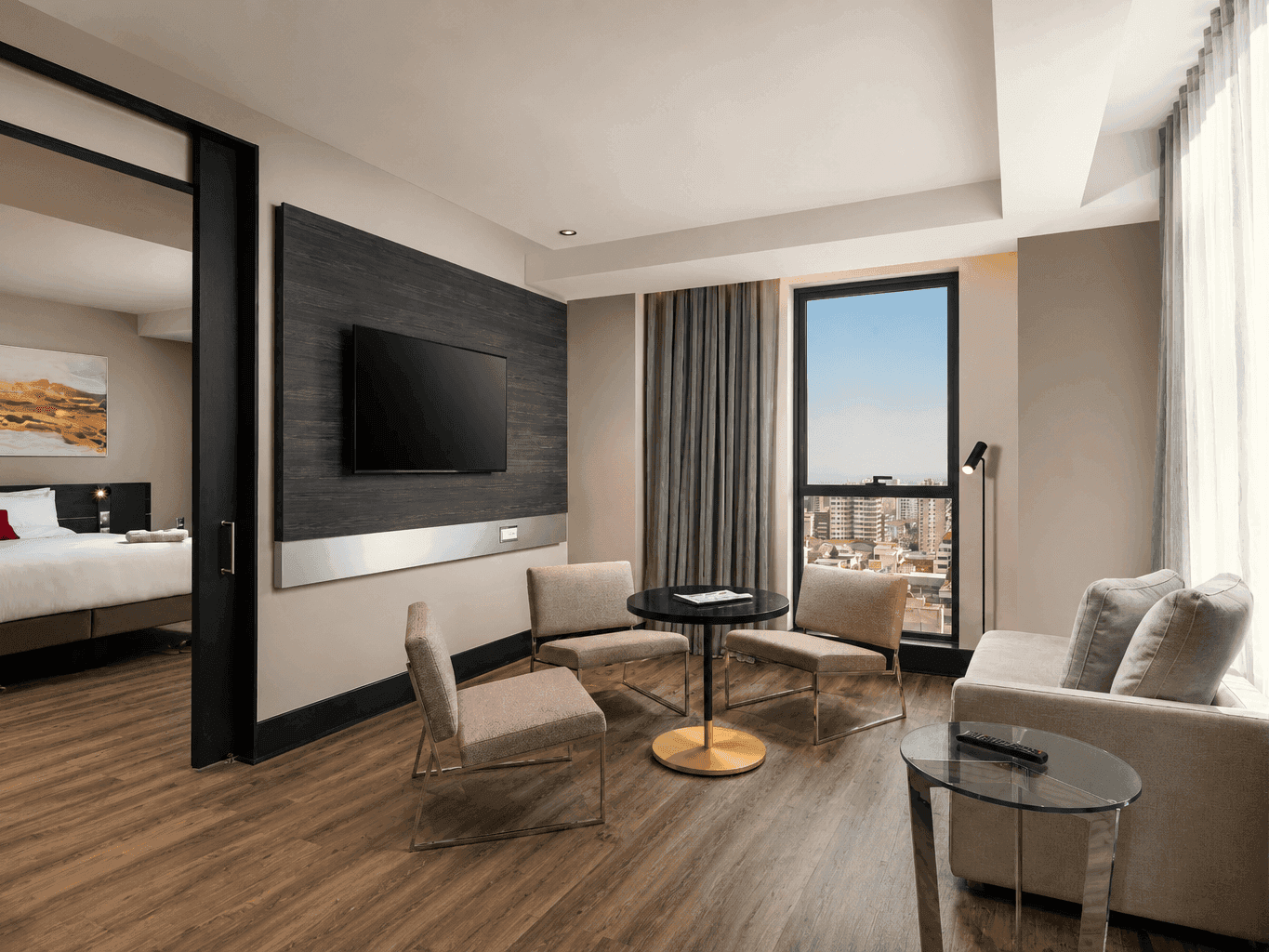 Amplia sala de suite con sofá y sillas junto a una ventana en Veranda Hotel con habitaciones que admiten mascotas