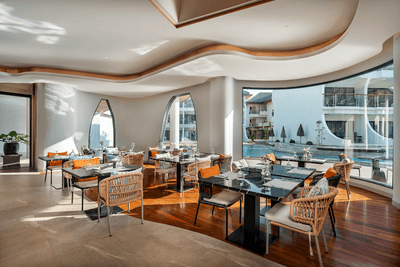 Dining tables arranged in Jamison Club with an elegant interior and pool view at Amora Hotel