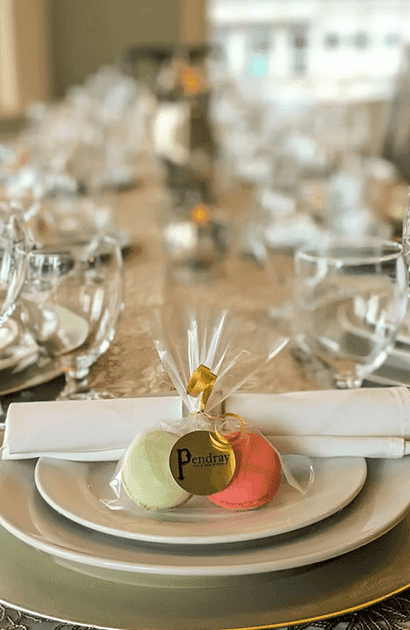 Close-up of glassware & macaron goodie bag on a table at Huntingdon Manor