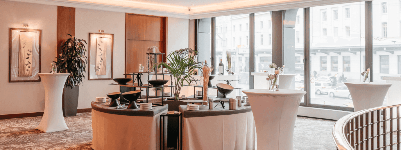 Des présentations de boissons raffinées et de grandes baies vitrées offrant une vue sur la ville au Foyer Mezzanine du Warwick Genève