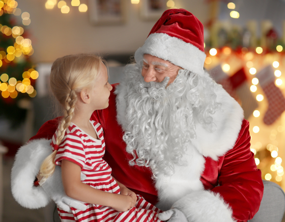 Young girl sits on Santa's lap as part of our breakfast with Santa Cape May hotel package