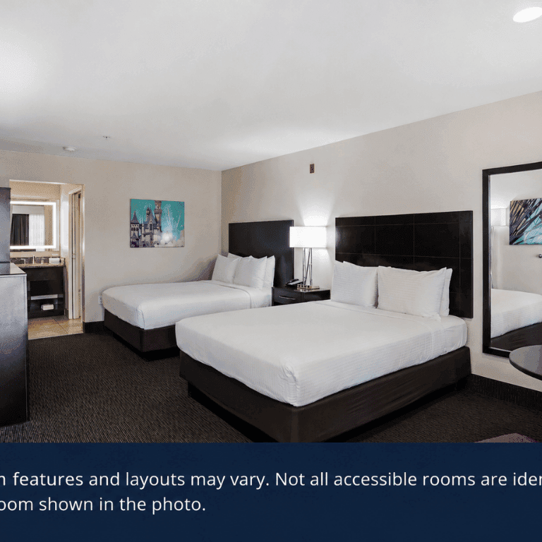 Spacious hotel room with two queen beds, modern furnishings, and accessible features near Disneyland®