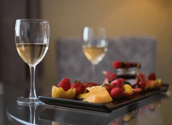Fresh fruit platter paired with white wine glasses at Rodd Grand Yarmouth, a luxury hotel in Yarmouth