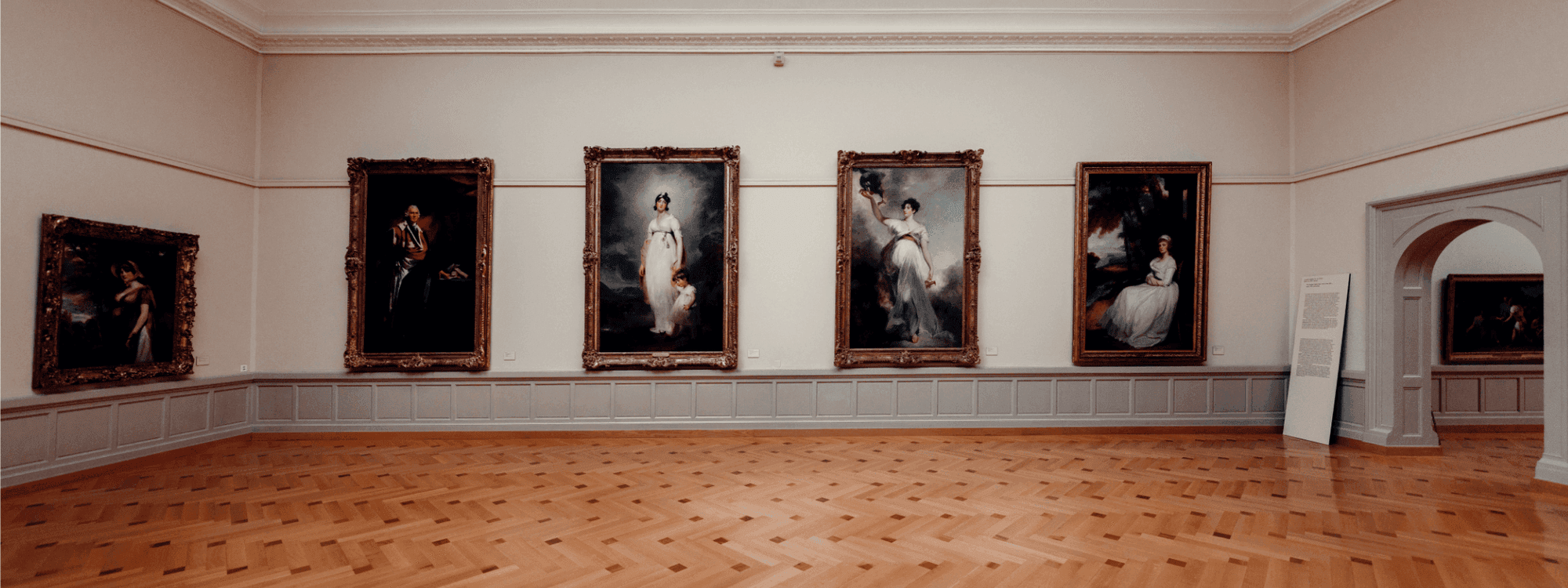 Wooden floored gallery with framed artworks on wall at Musée d'Art et d'Histoire.