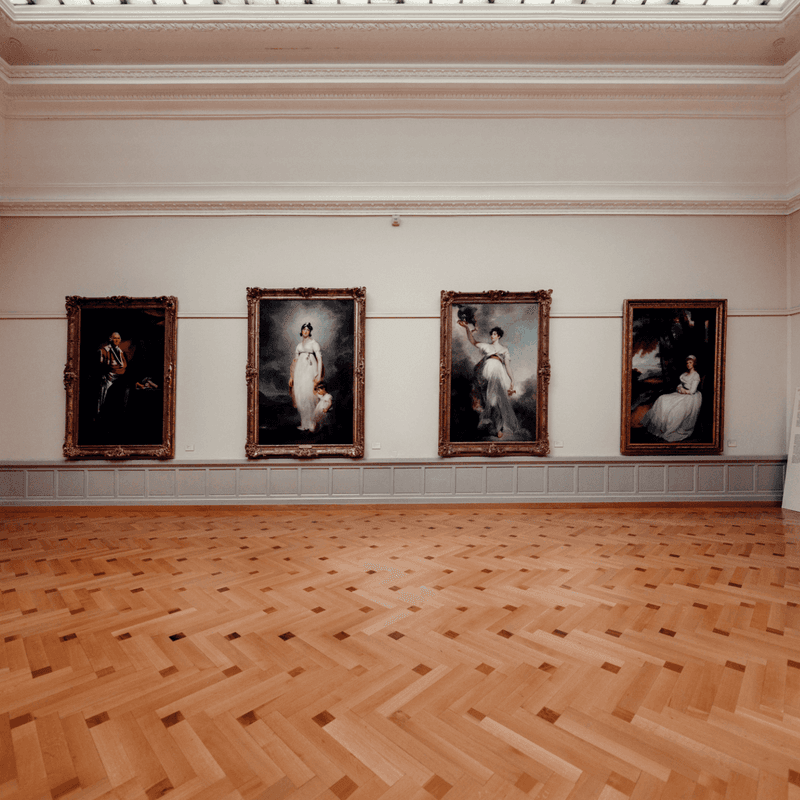 Wooden floored gallery with framed artworks on wall at Musée d'Art et d'Histoire.