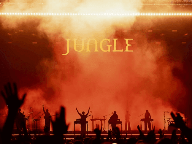 Performers on stage with Jungle World Tour - 2027 text and audience raising hands.