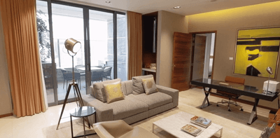 Livingroom area with cozy sofa, abstract art, and work desk in Lotus Apartments at One Farrer Hotel