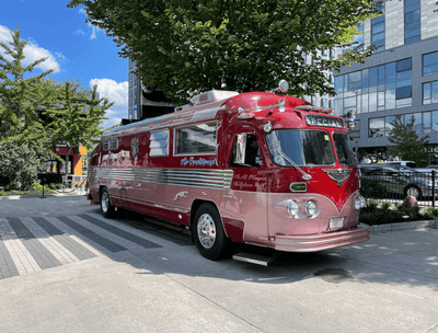 A red bus parked on a city street near The Verb Hotel