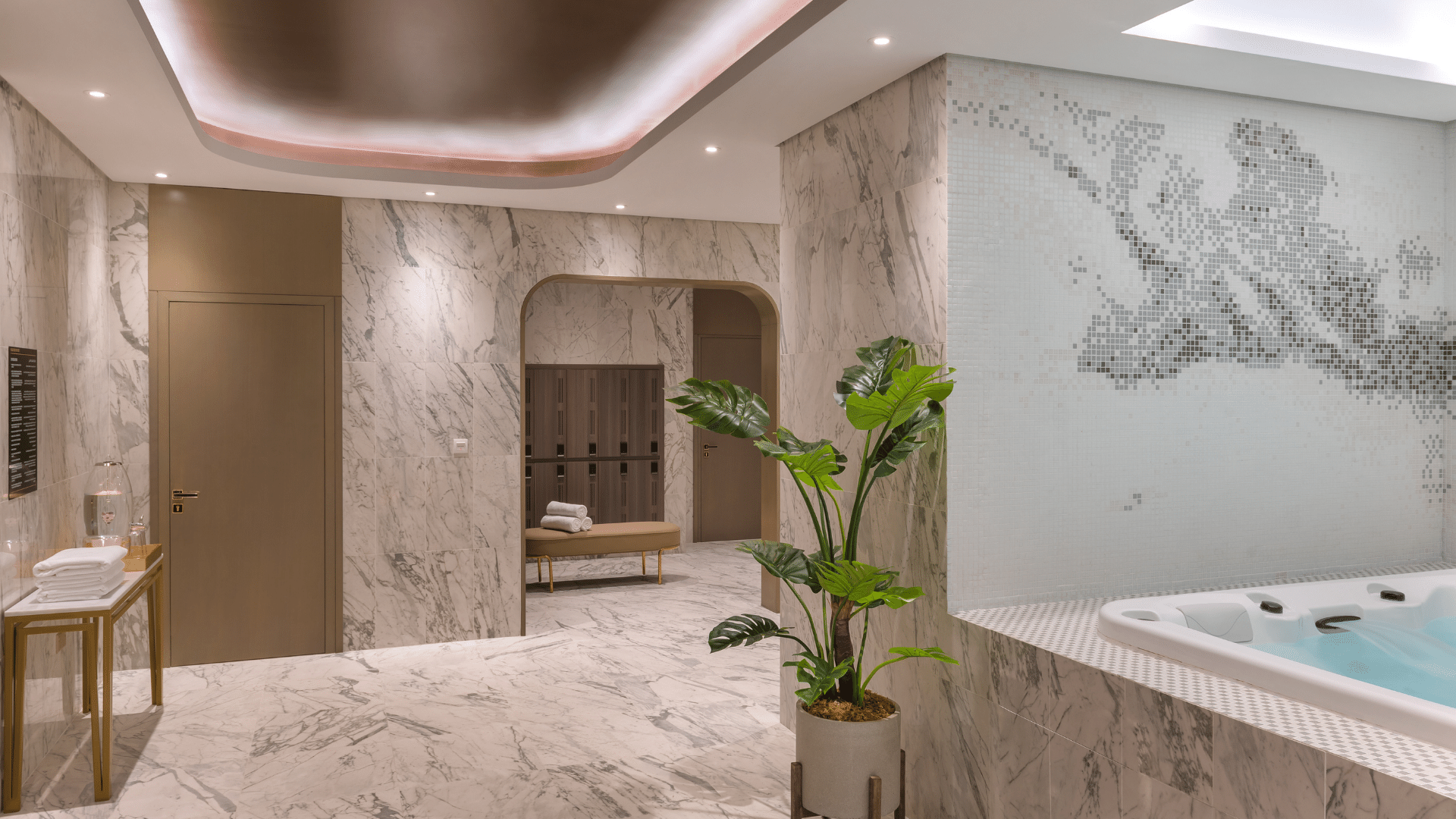 Luxurious jacuzzi room with marble accents, subtle lighting, and a tropical plant at Paramount Hotel Midtown spa