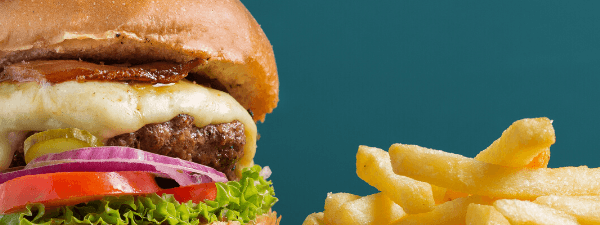 A delicious cheeseburger with golden, crispy French fries featuring Solo Takeaway at Novotel Sunshine Coast Resort