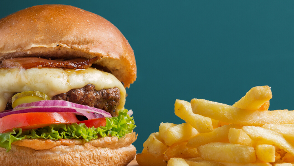 A delicious cheeseburger with golden, crispy French fries featuring Solo Takeaway at Novotel Sunshine Coast Resort