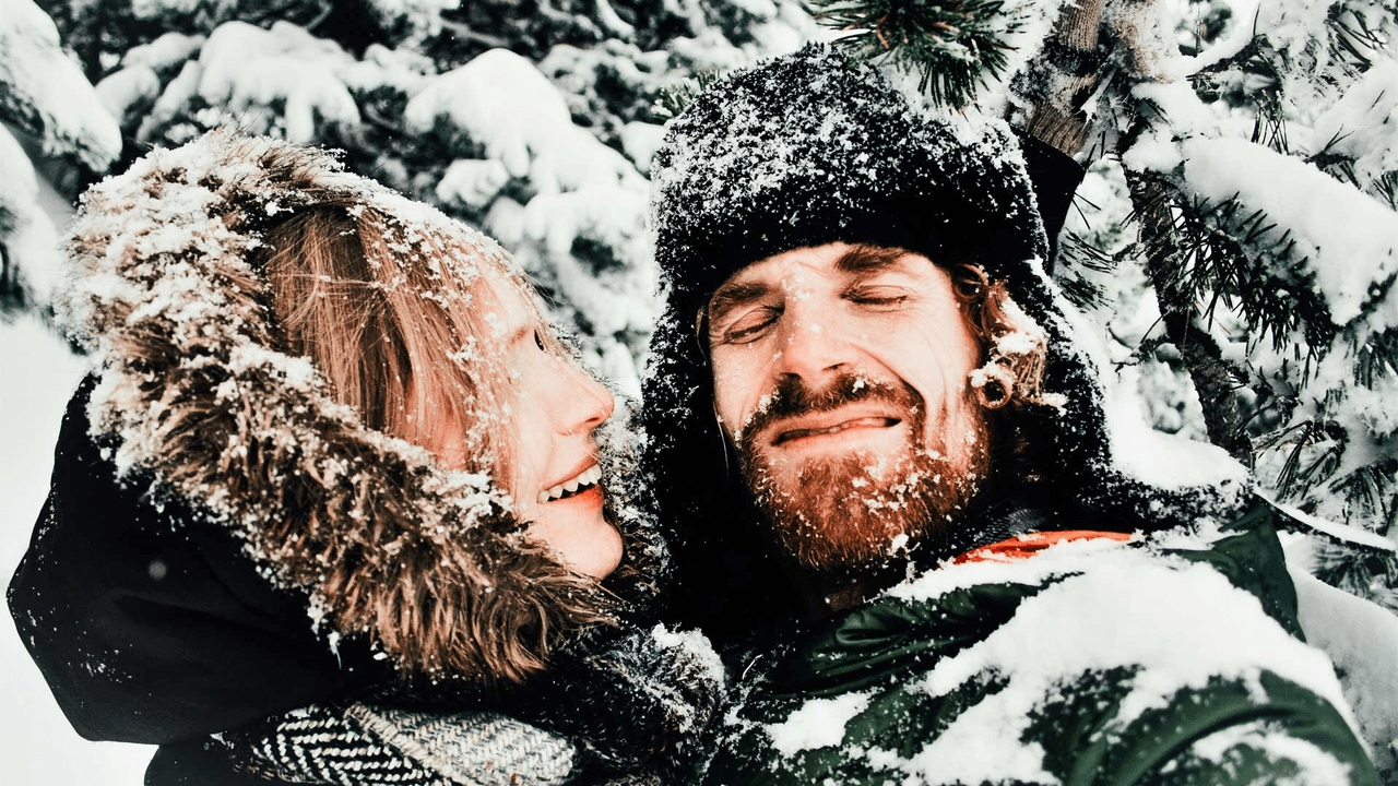 A couple covered in snow posing for the camera