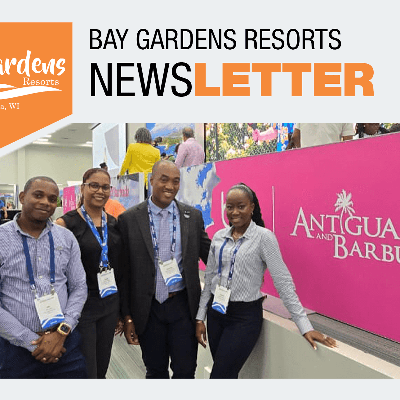 Banner with staff wearing name tags by a Antigua & Barbuda sign at Bay Gardens Beach Resort & Spa