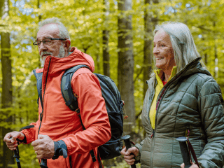 Active senior couple trekking through a picturesque mountain path in the fresh spring air