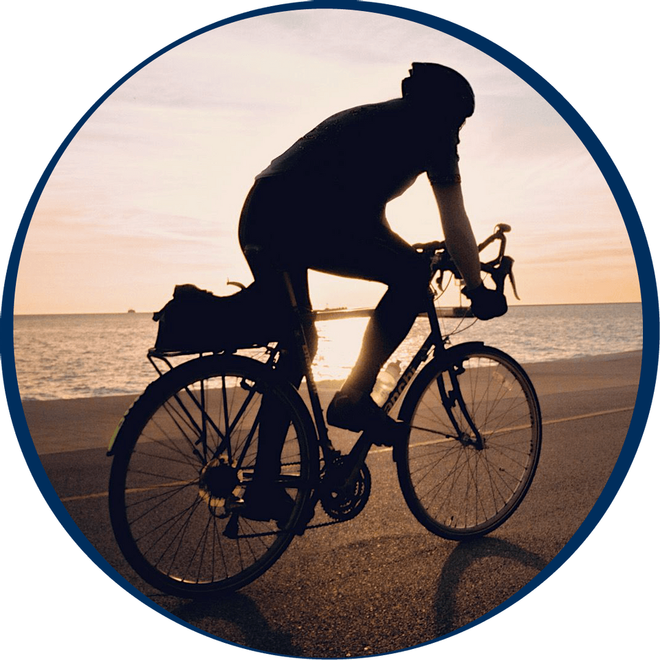 A guy riding a cycle in Falmouth Beach near Falmouth Tides