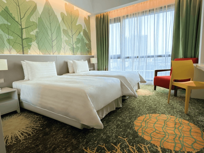 Two beds and chairs in a Deluxe Plus Twin Room at Sunway Velocity Hotel Kuala Lumpur.