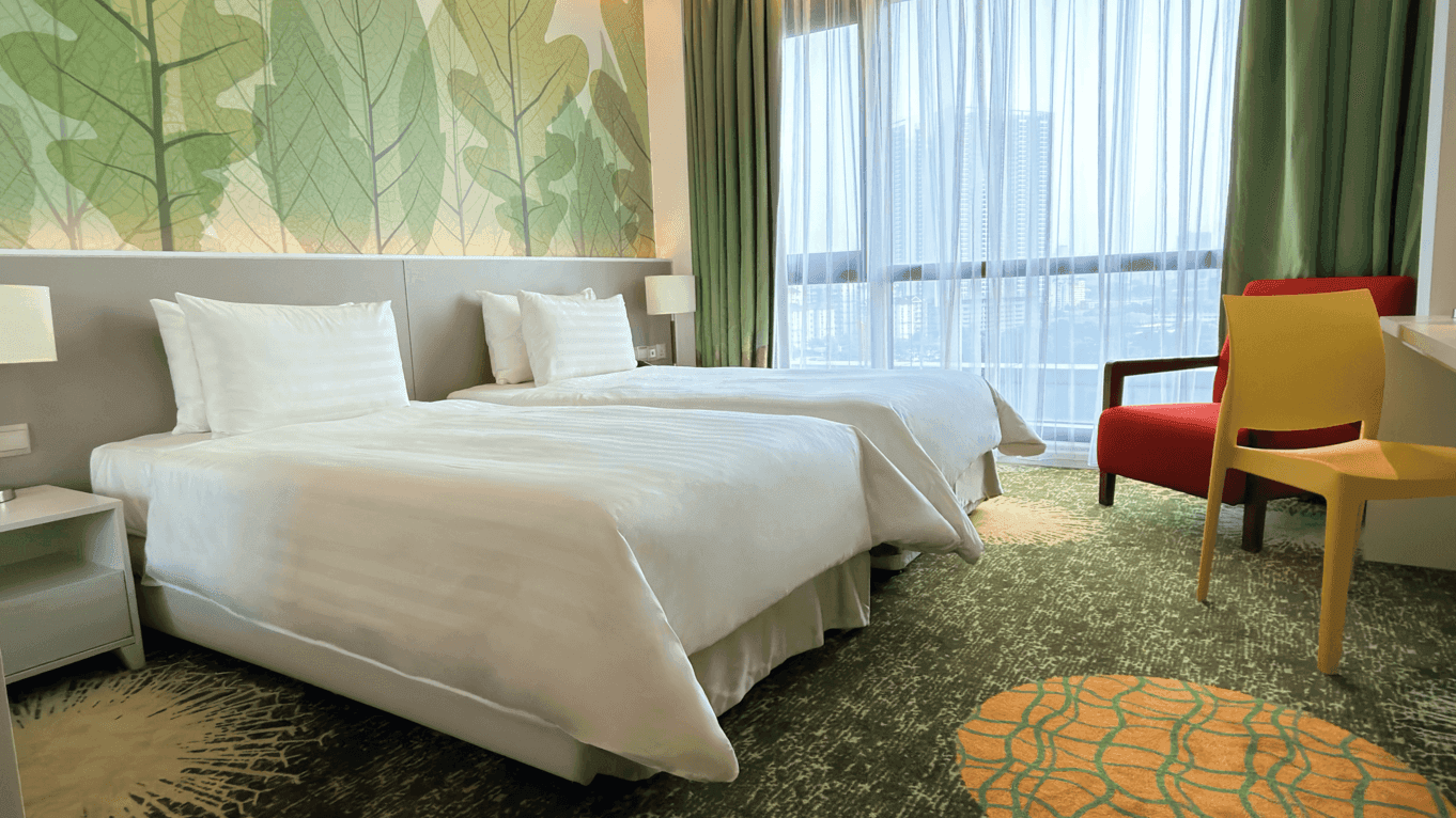 Two beds and chairs in a Deluxe Plus Twin Room at Sunway Velocity Hotel Kuala Lumpur.