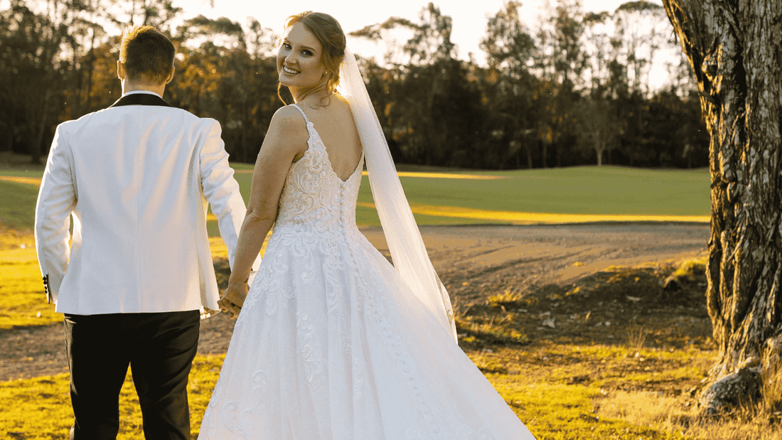 A bride and groom walking hand in hand near Mercure Kooindah Waters