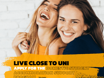 Two female students embracing against a white brick wall in a promotional image for UniLodge Park Avenue.
