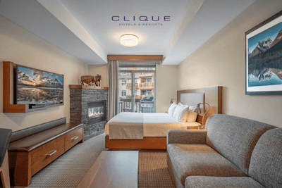 Comfortable suite at Falcon Crest Lodge features a king-size bed, a cozy sofa, a fireplace with decorative moose