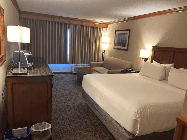 King room with a comfortable bed, couch, and a balcony at Lake Placid Club Grandview