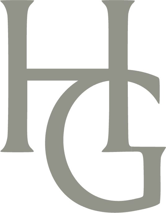 Gray monogram logo featuring intertwined letters H and G on black background at Hotel Granduca