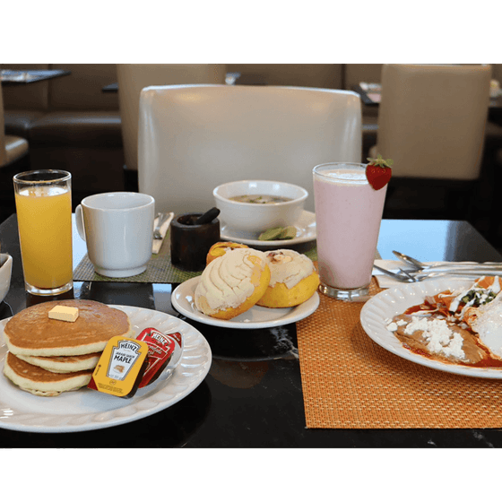 Mesa de desayuno con panqueques, pan dulce, chilaquiles, bebidas y batido en Italiano Cucina & Bar de Araiza Calafia