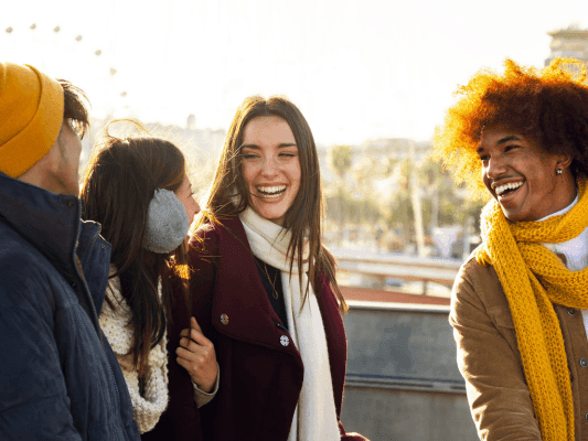 Four people smiling together in winter clothing, promoting Winter Sale - Save 18%.