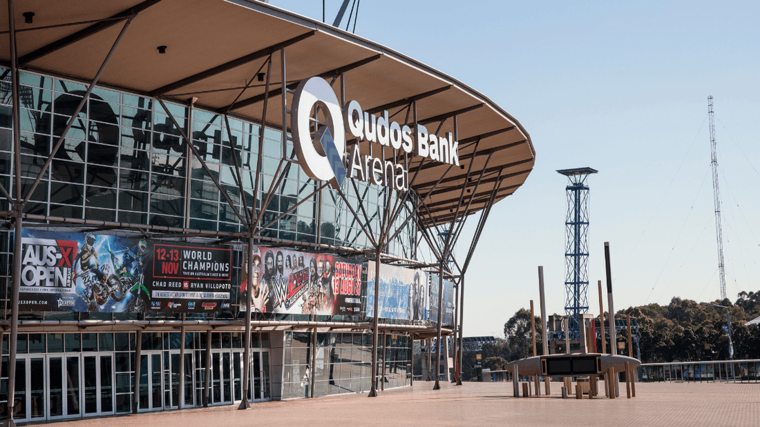 The exterior of the Quodos Bank Arena with large glass walls and banners displayed.