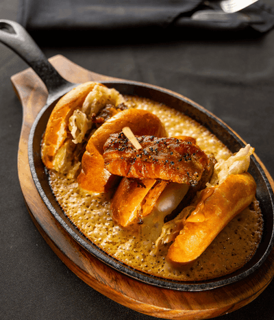 Savory gourmet sliders served in a hot cast-iron skillet on a wooden board at the restaurant inside Rodd Royalty