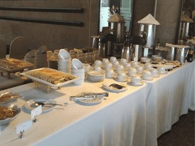 Lavish buffet spread featuring various dishes, stacked plates, and beverage dispensers at Hotel Los Delfines & Casino