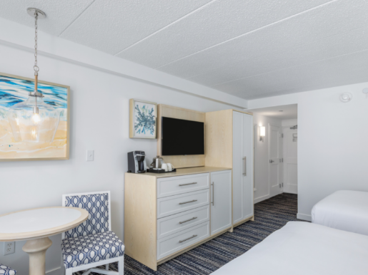 Signature Queen Hotel Room in Avalon NJ with bistro table, 2 beds, white dresser with tv