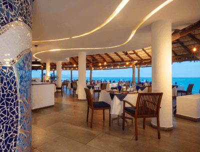 Arrangement of dining tables with ocean view in Sunset Restaurant at Buenaventura Grand Hotel and Spa