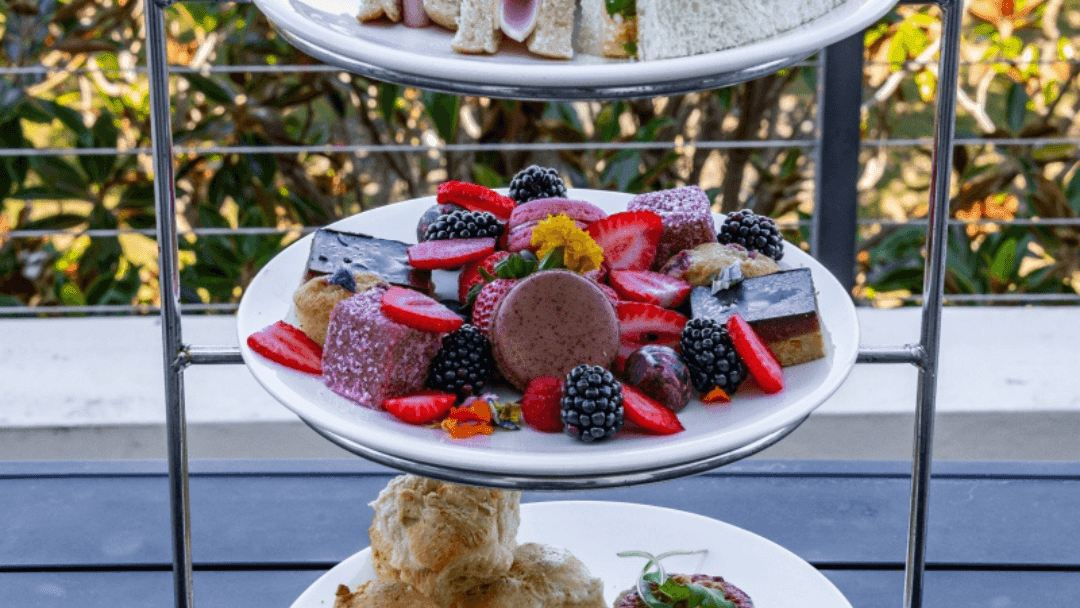 Three-tiered afternoon High Tea stand with sandwiches, scones, and assorted desserts at Mercure Kooindah Waters