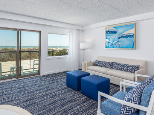 Oceanfront Suite at ICONA Windrift Resort in Avalon NJ Living area with pull out couch, sitting chairs, and dining table
