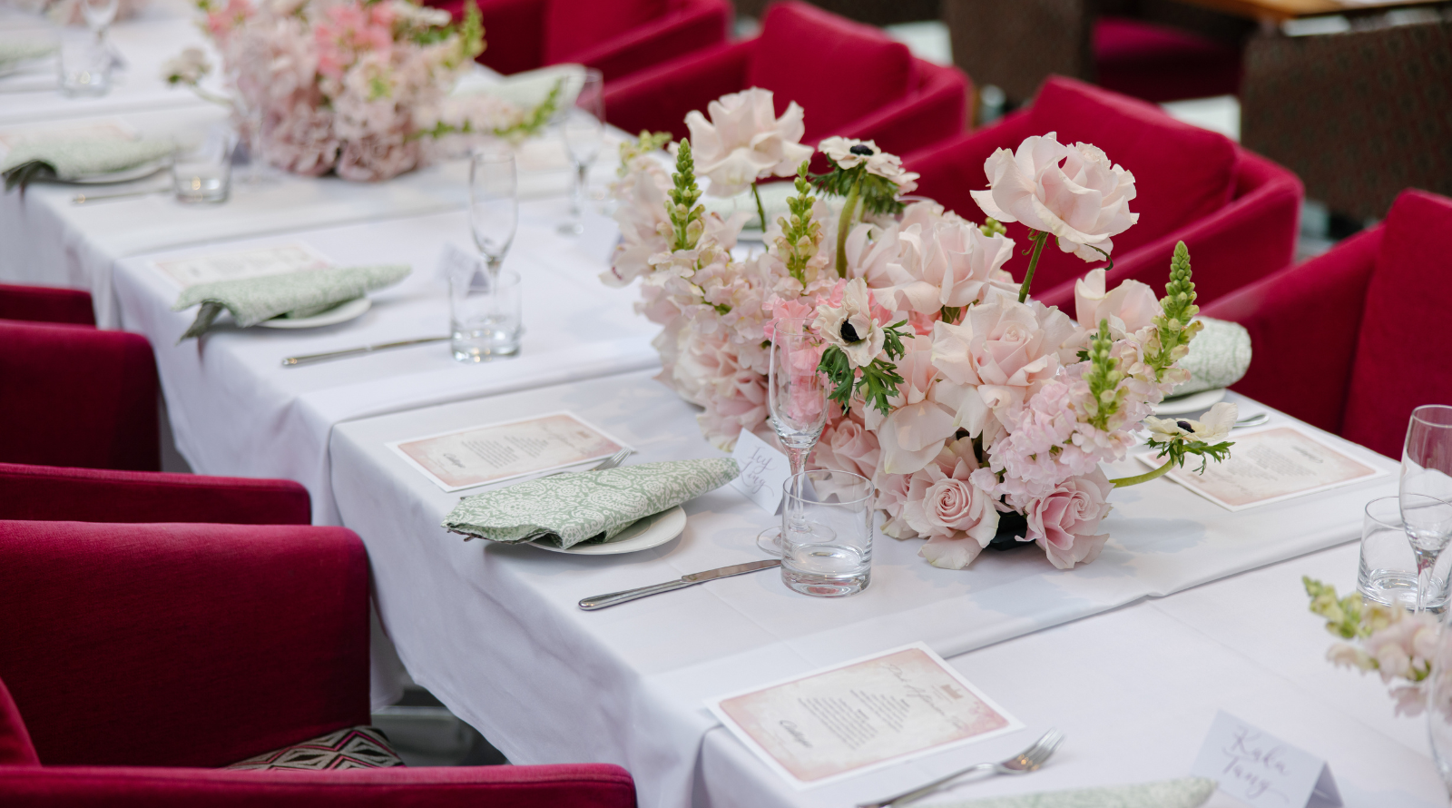 A long table adorned with pink chairs and flowers at Fullerton Sydney